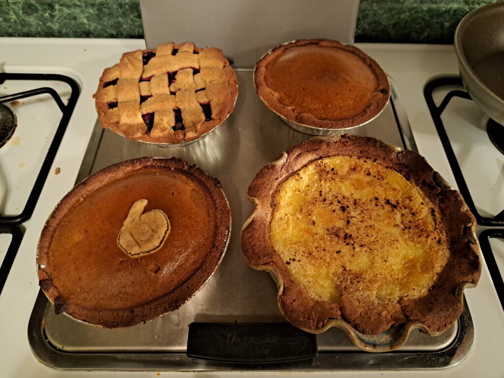 A selection of mini-thanksgiving pies: pumpkin, cherry, and hoosier pie.
