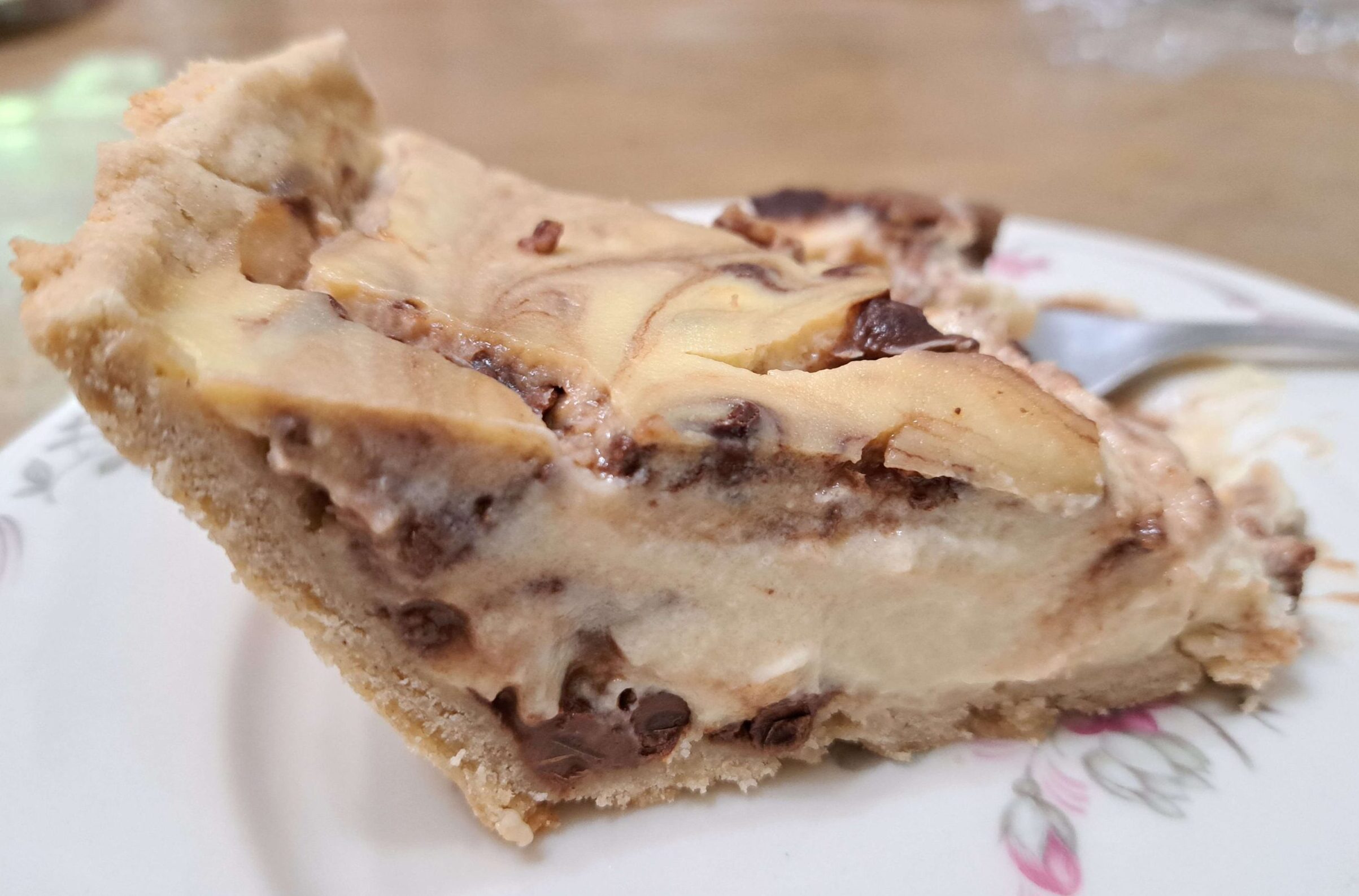 A slice of gluten-free vanilla-rum custard pie with chocolate chips